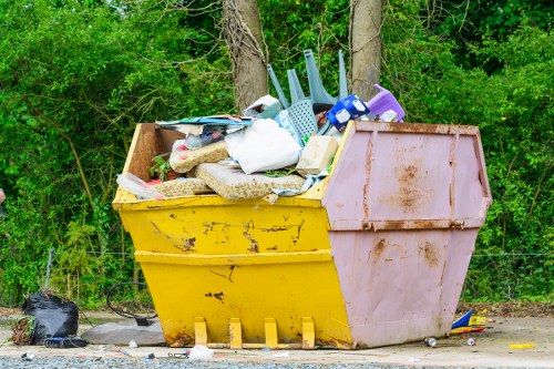 Workers sorting household items into recycling and donation piles at a clearance site